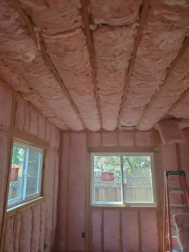 Fiberglass batts installed in the walls and ceiling of a remodel