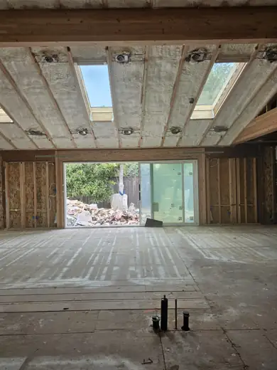 Spray foam insulation sprayed across a ceiling between rafters