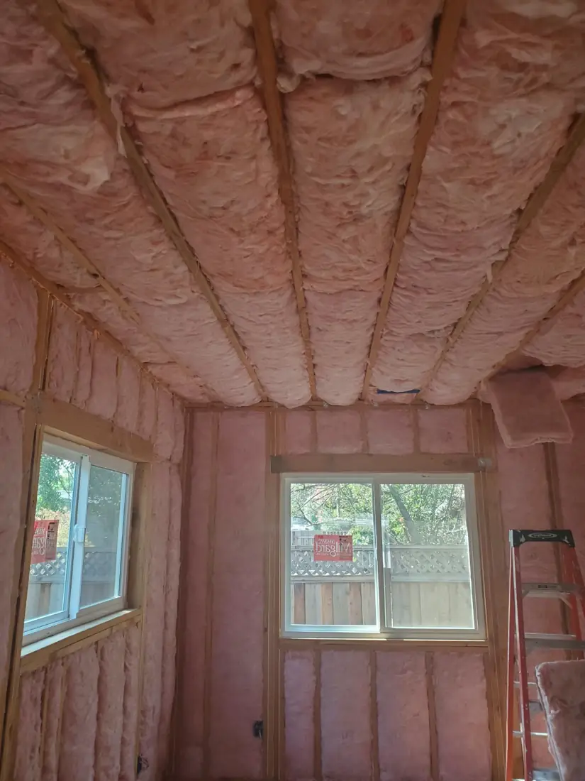 Fiberglass batts installed in walls and ceiling of a room addition